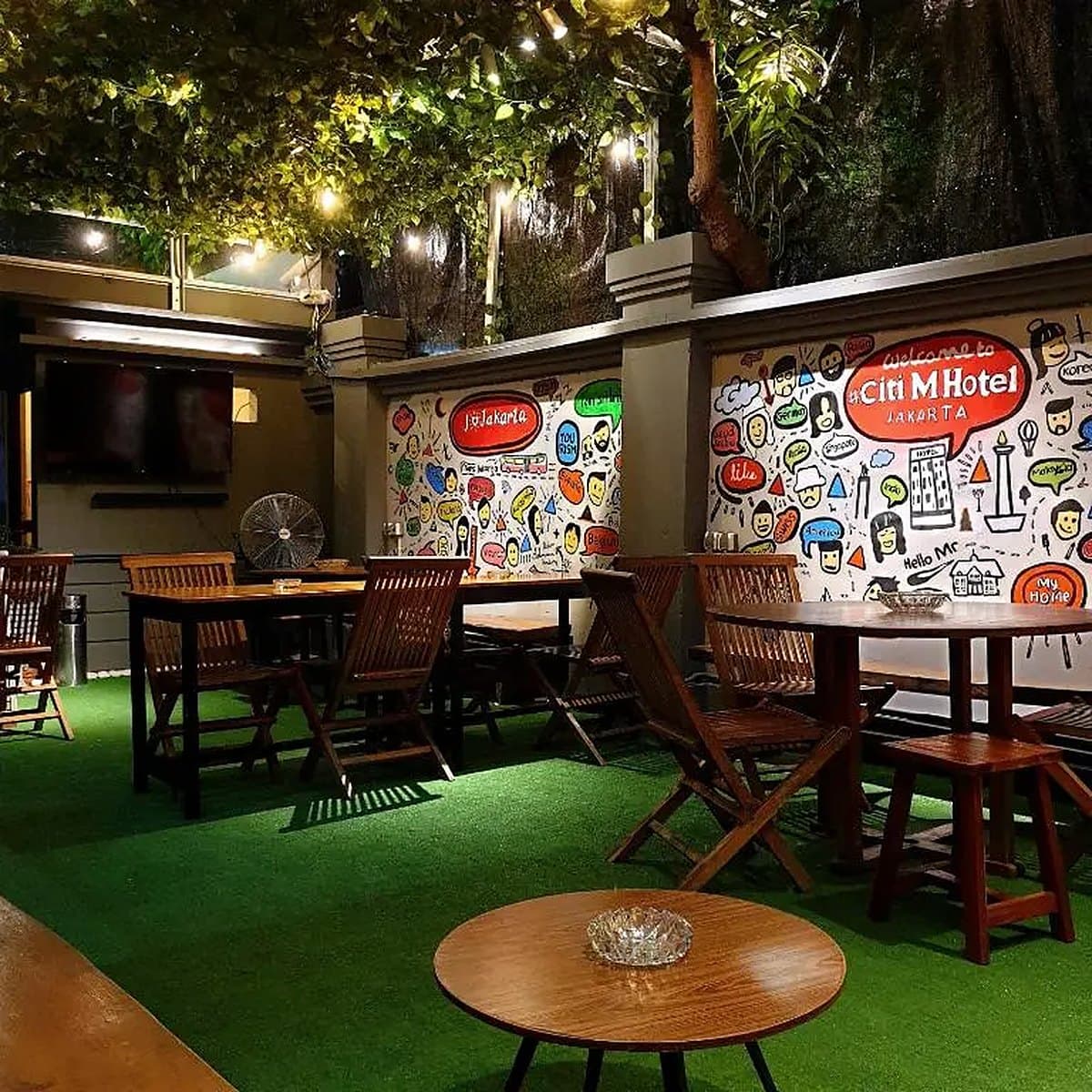 Teras terbuka dengan mural dan lampu hias